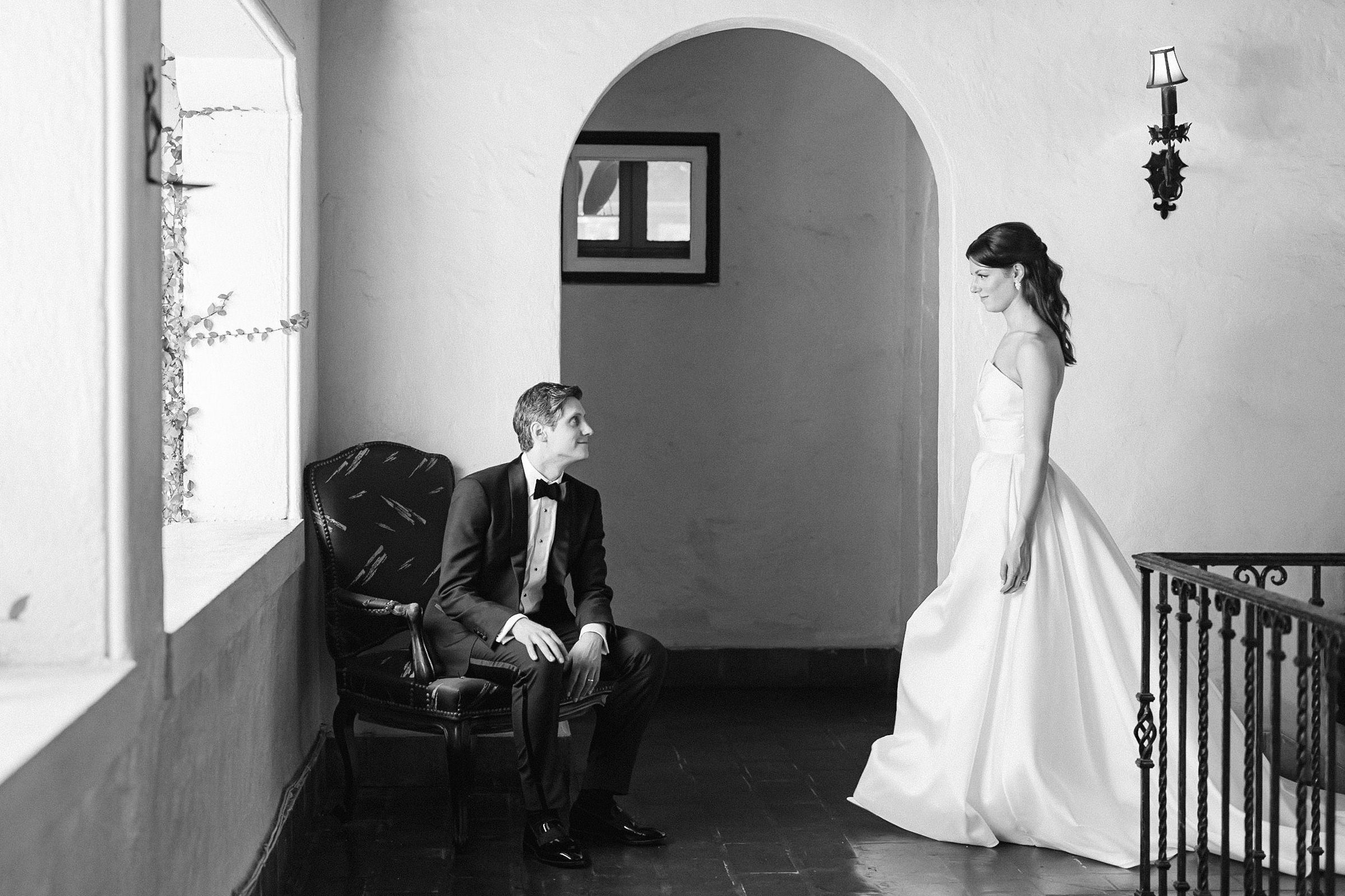 black and white editorial portrait of a bride walking toward the seated groom at Villa Woodbine