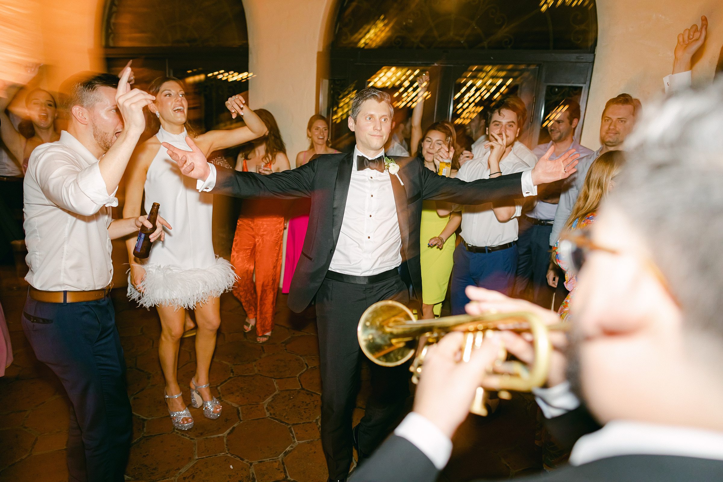 Groom dancing with trumpet player
