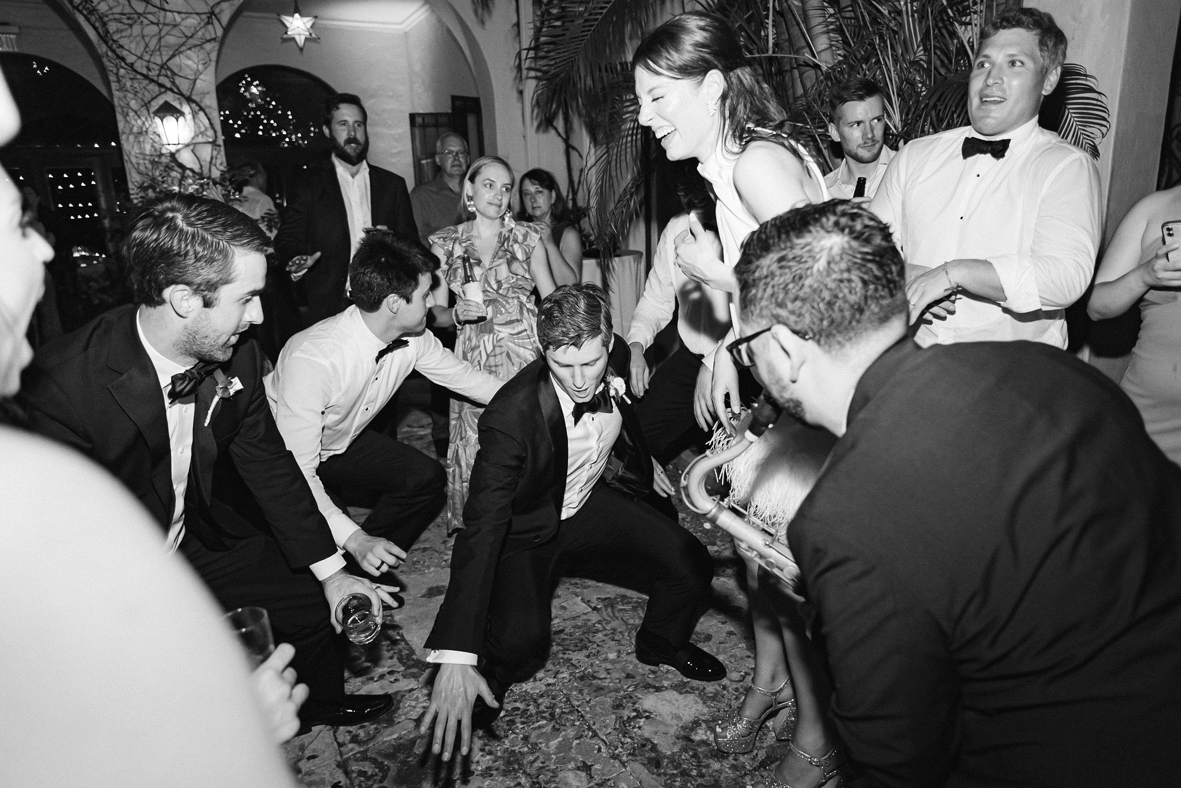 Black and white image of the bride and groom laughing during the reception dancing