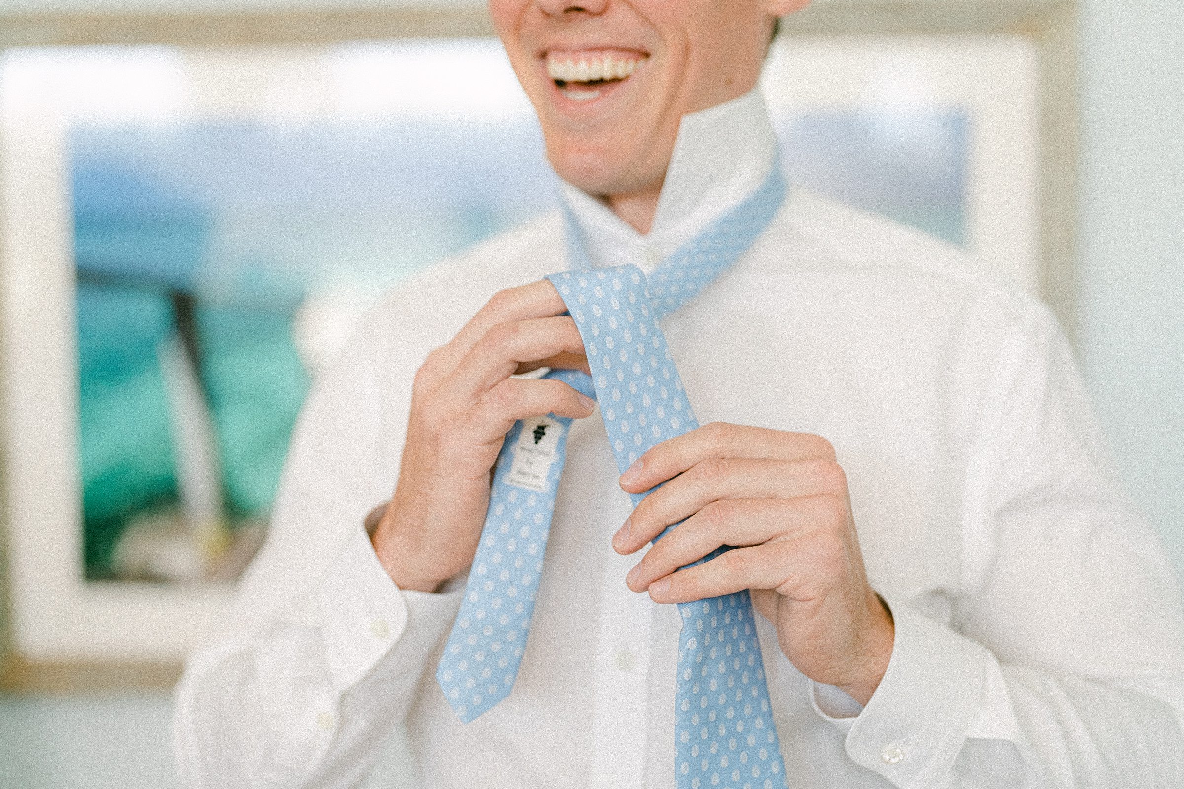 abstract photo of the groom putting on his baby blue tie