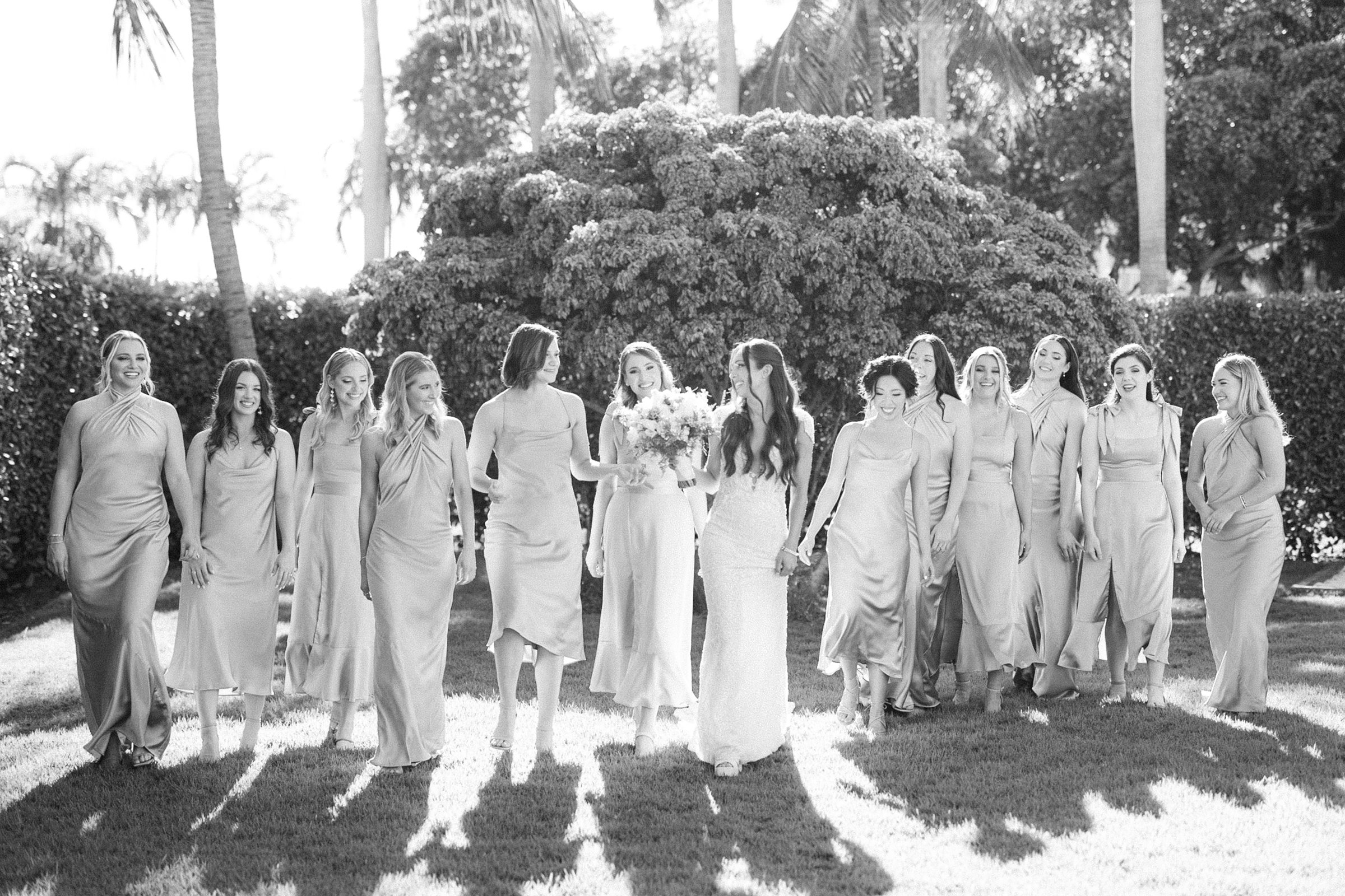black and white group photo of the elegant bridesmaids walking down the lawn with the bride in the center