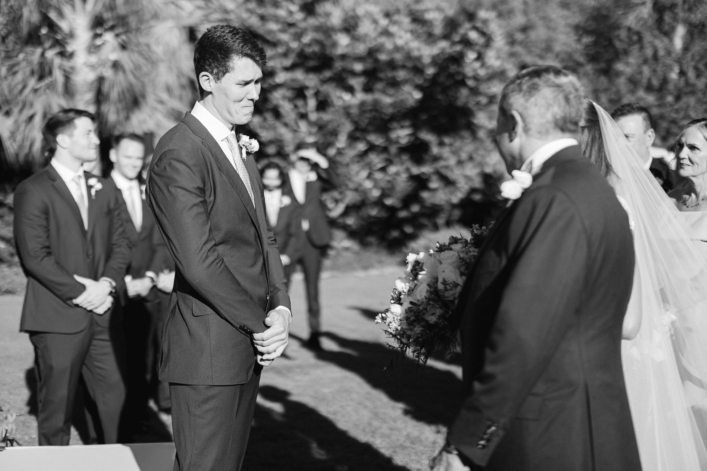 a black and white image of the grooms emotional reaction to seeing the bride