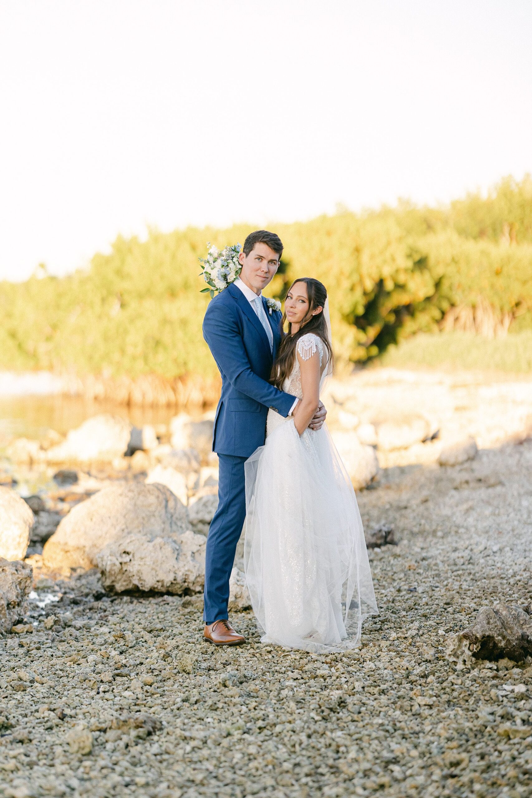 bride and groom portrait by the rocky beach