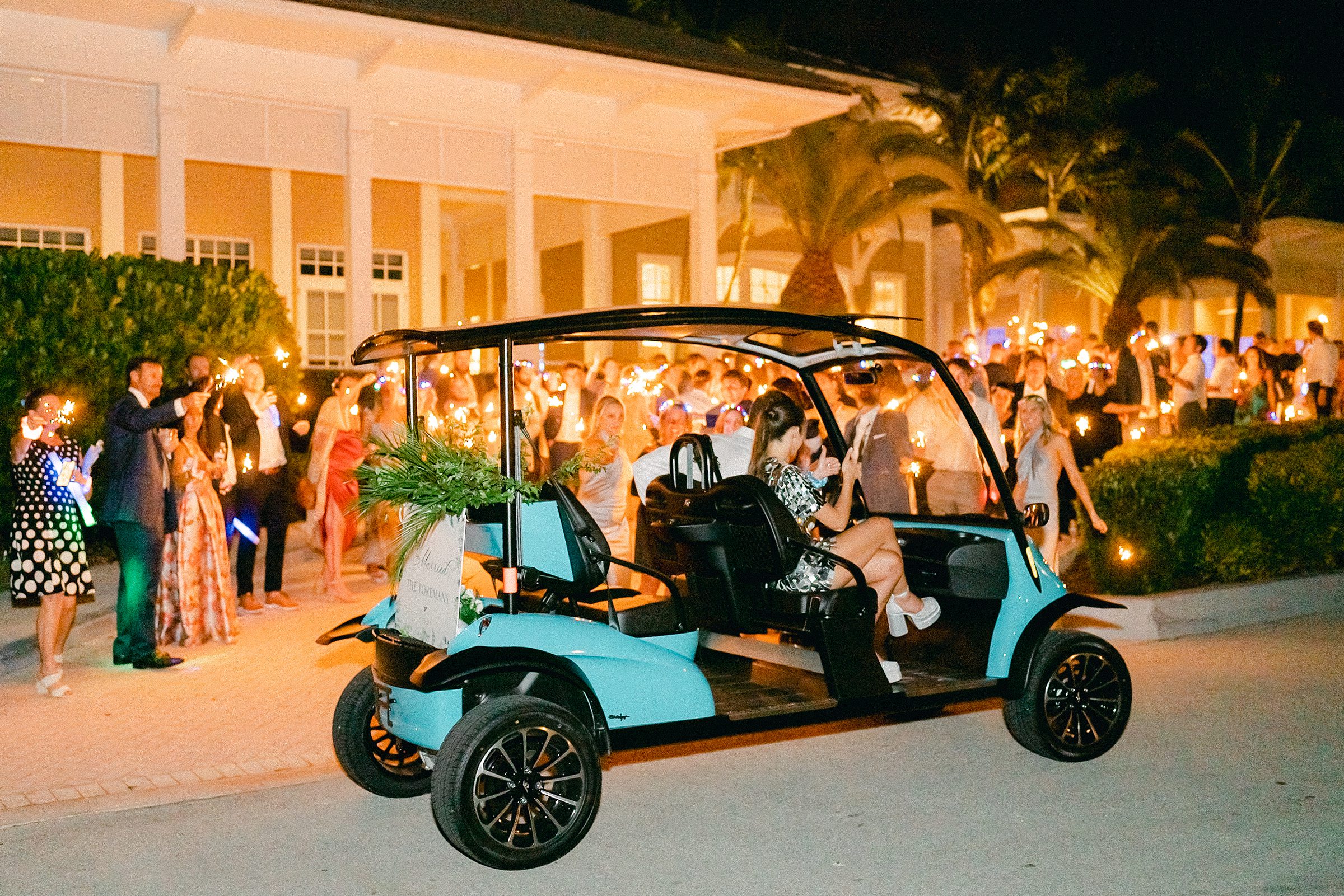 bride and groom leaving their reception venue at ocean reef club in their tiffany blue golf cart