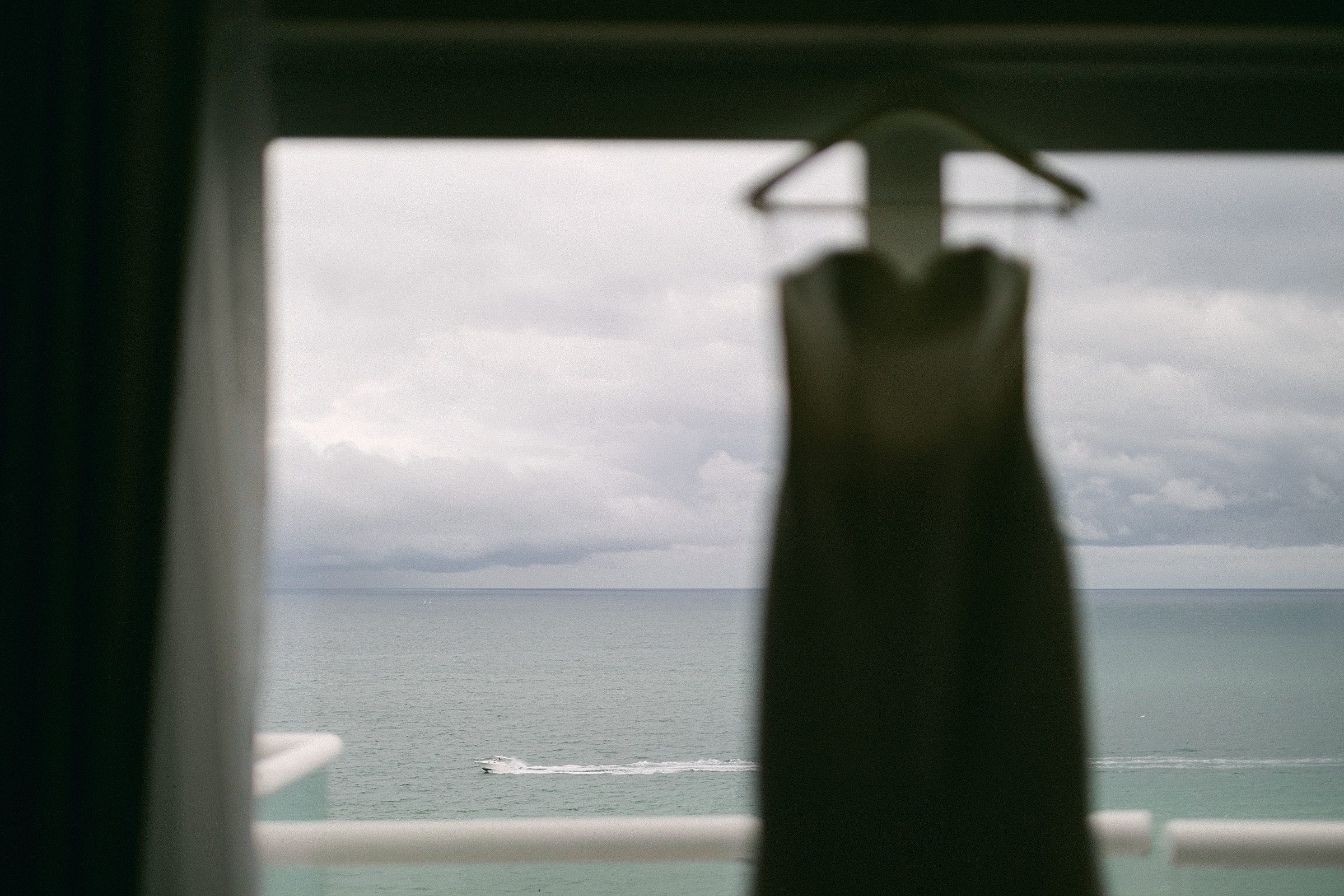 Creative composition of a wedding dress in the foreground with a speed boat racing in the background
