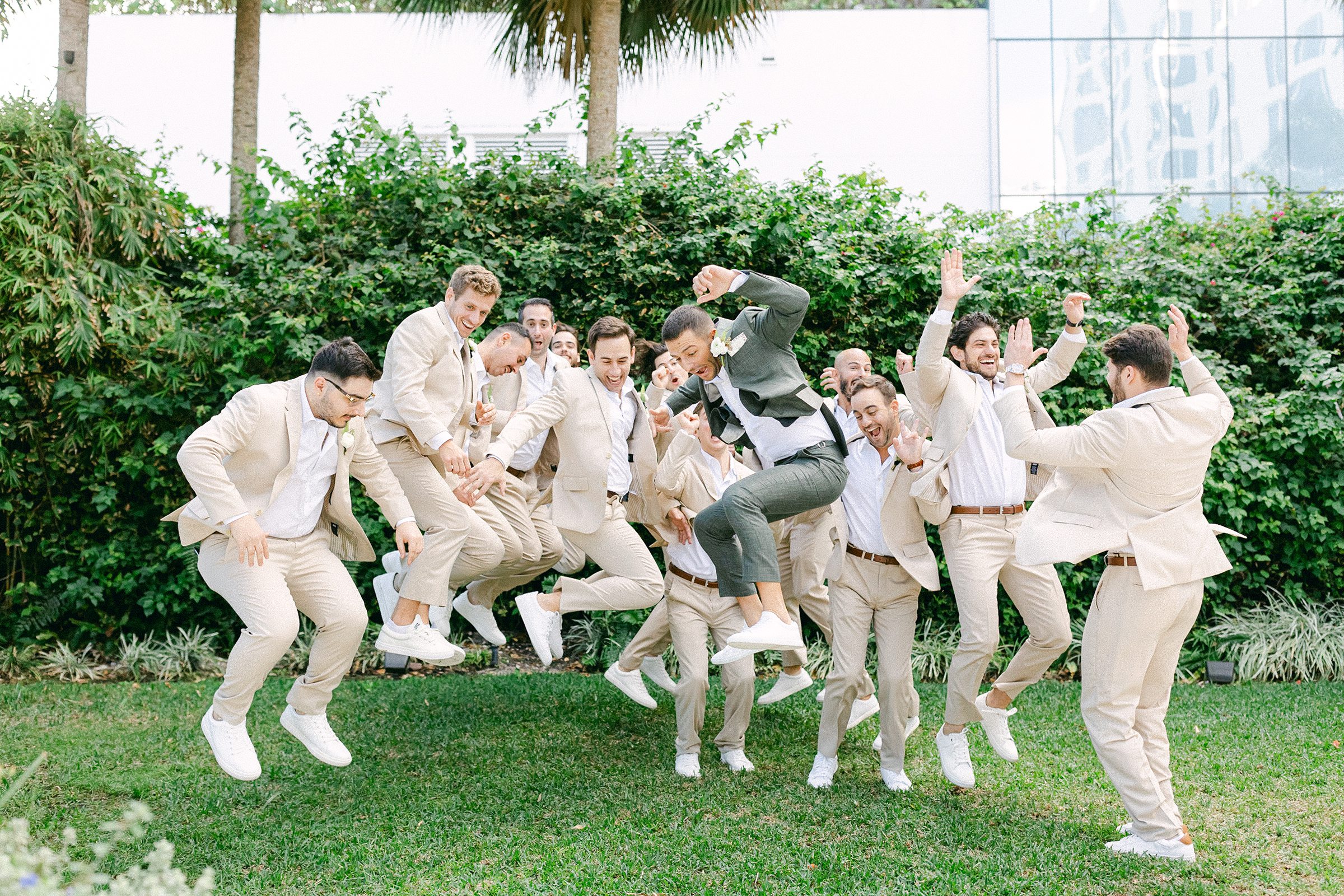 groomsmen group photo of them jumping in their tan suits