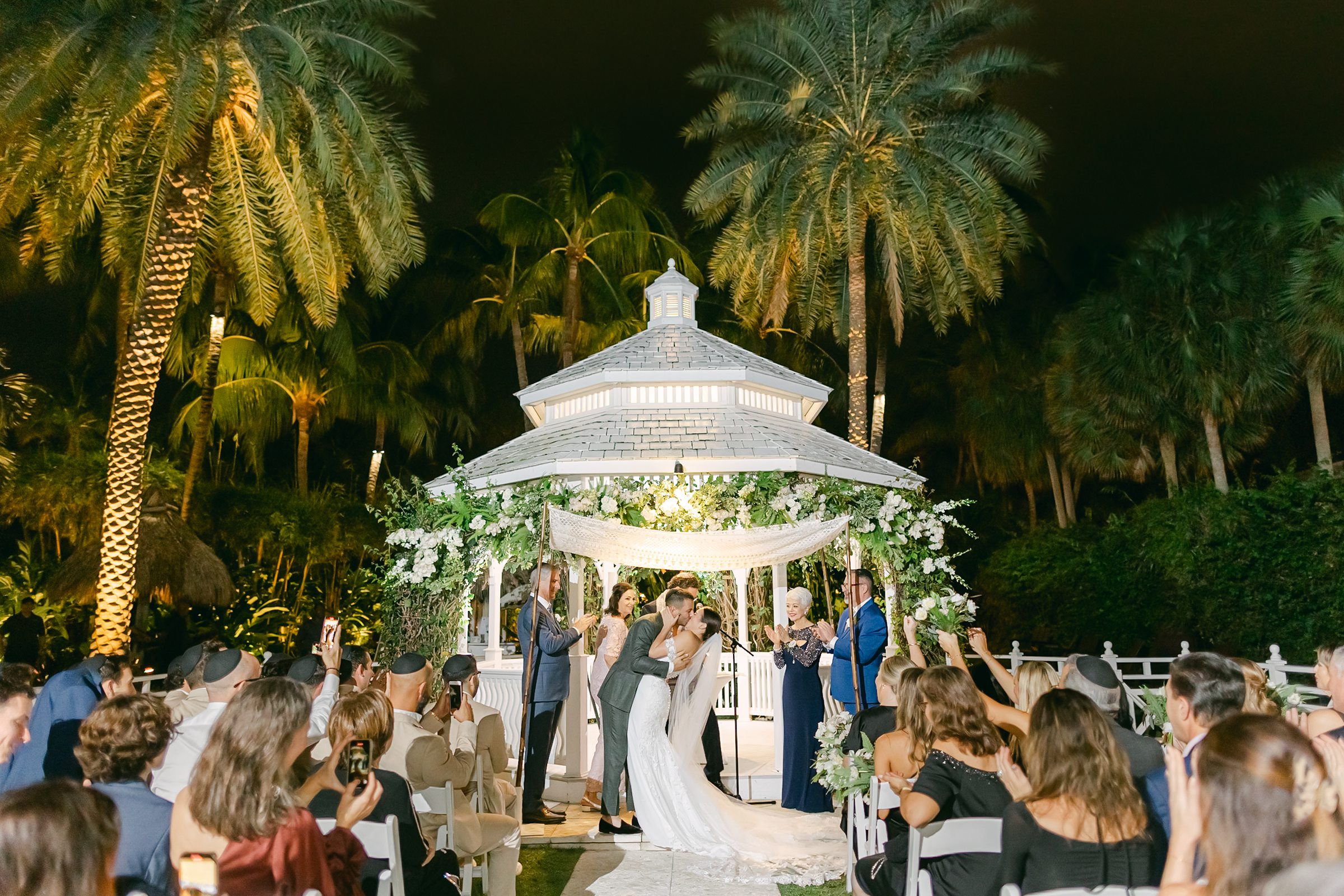 first kiss of the bride and groom under their jewish chuppah at the palms hotel and spa gazebo