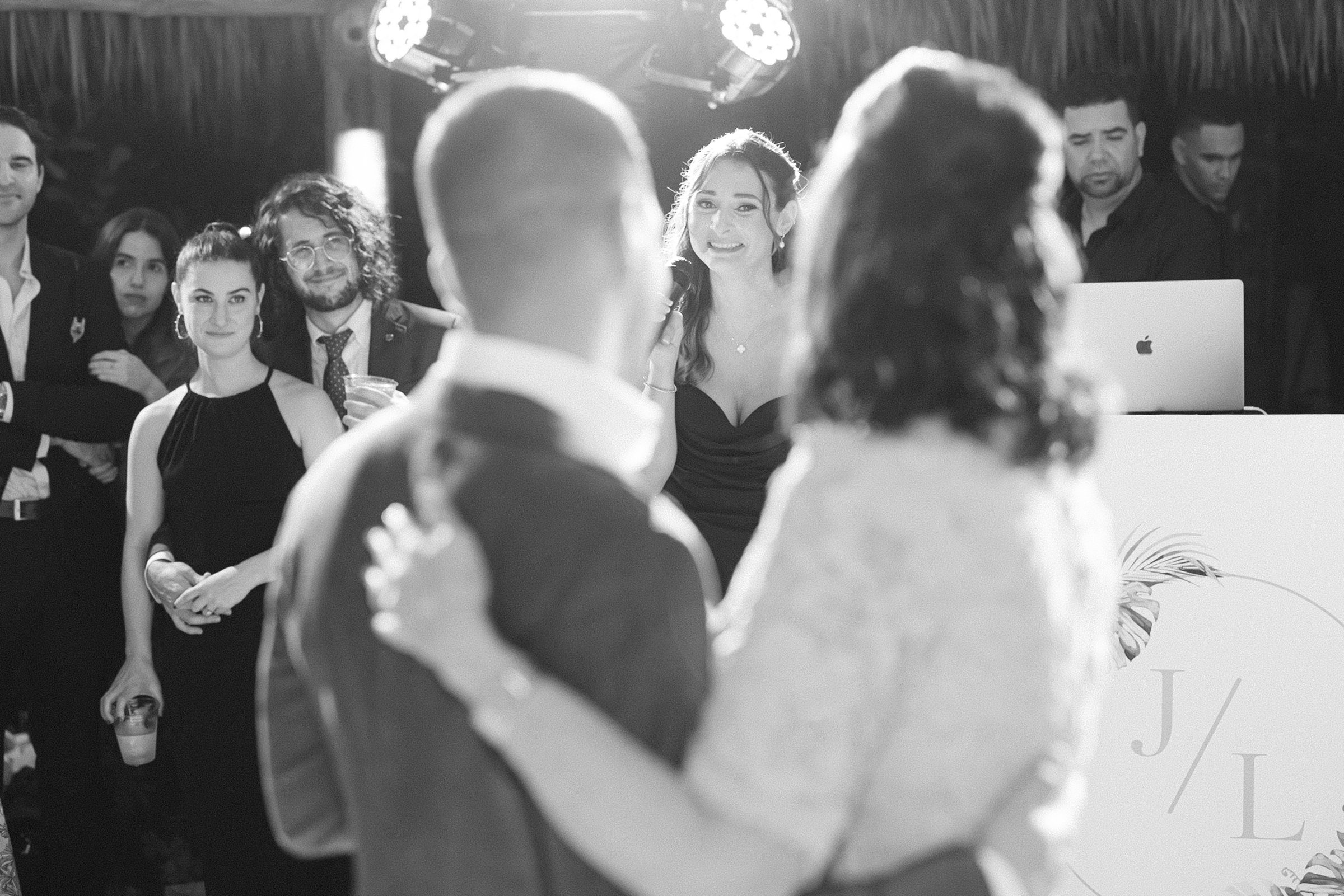 black and white image of the grooms sister singing during his first dance with his mother