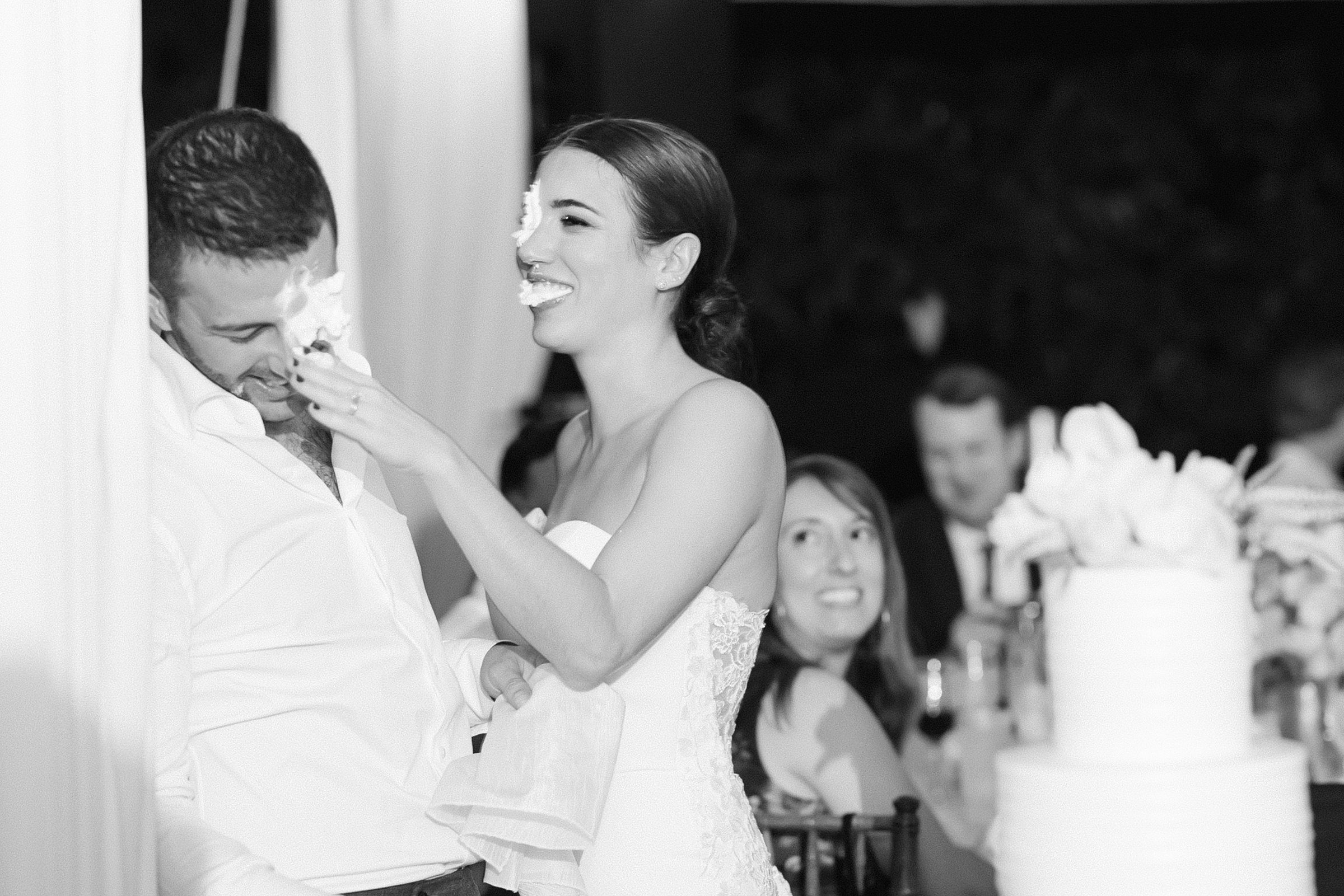 bride and groom have a whip cream fight at their cake cutting