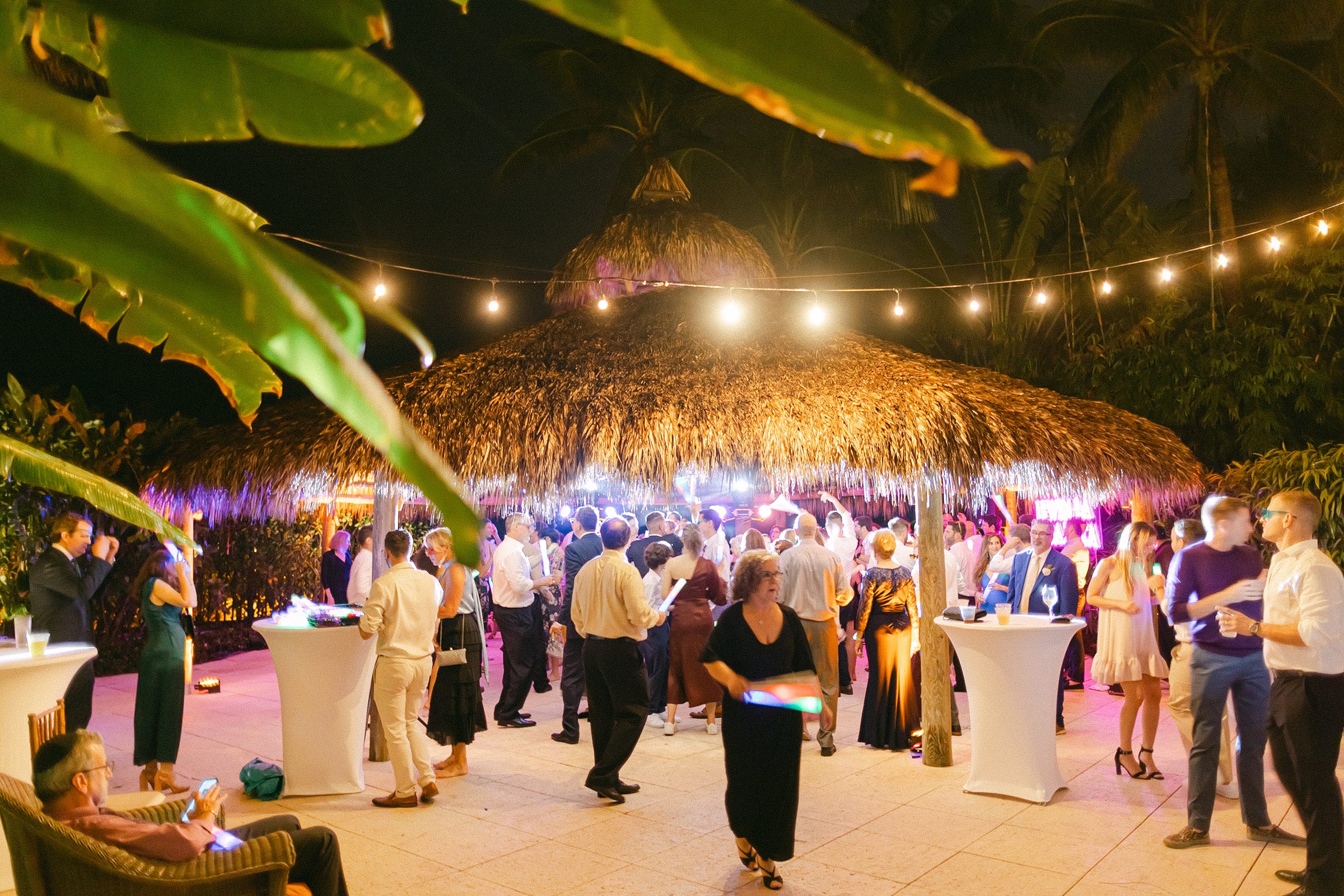 wide angle view of the tiki hut at the palms hotel and spa with guests dancing inside 