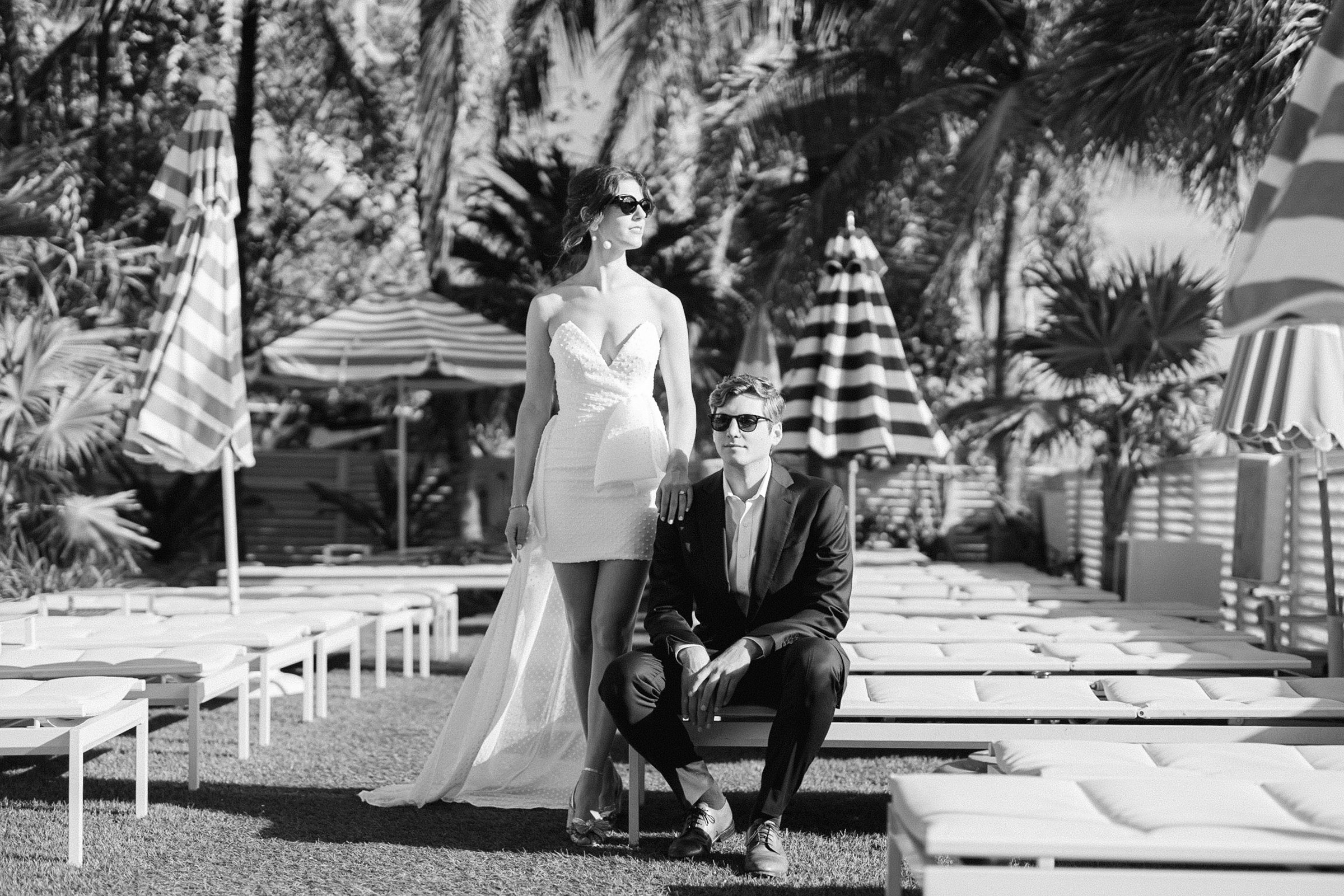 editorial black and white image of the engaged couple sitting by the tanning chairs