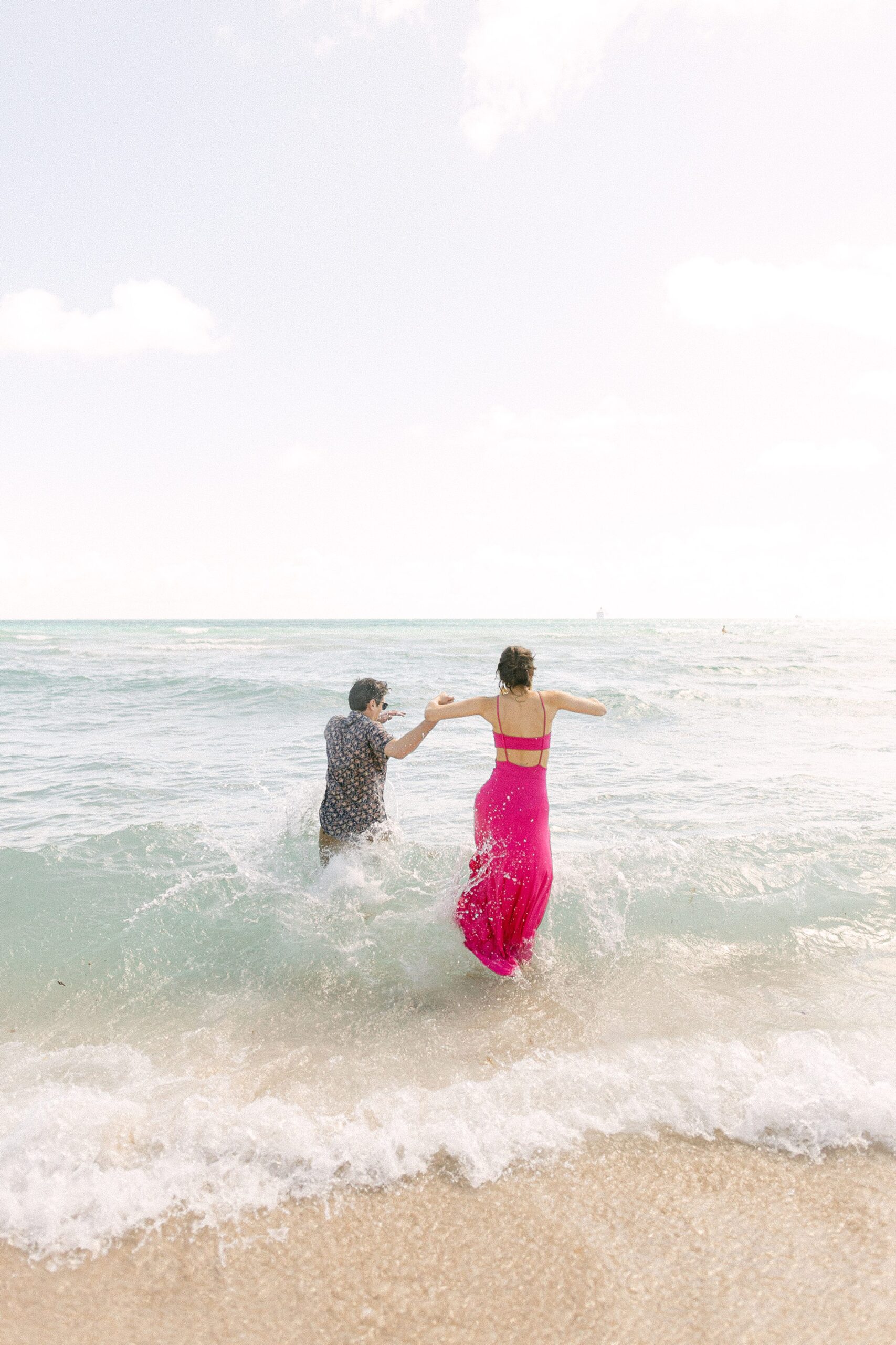 engaged couple jumping into the Miami Beach atlantic ocean