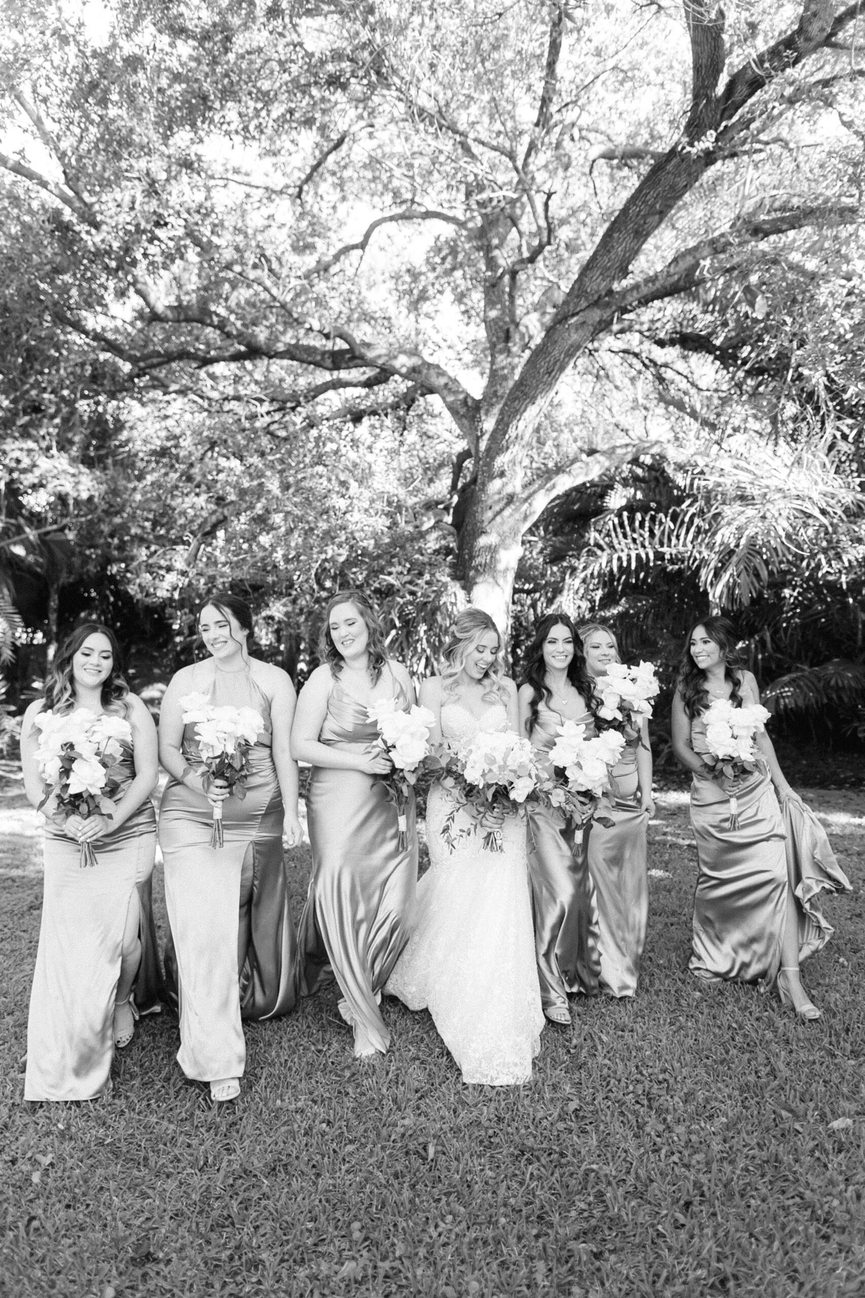 Black and white edit of the bride and bridesmaids walking in a group laughing at the Cooper Estate.