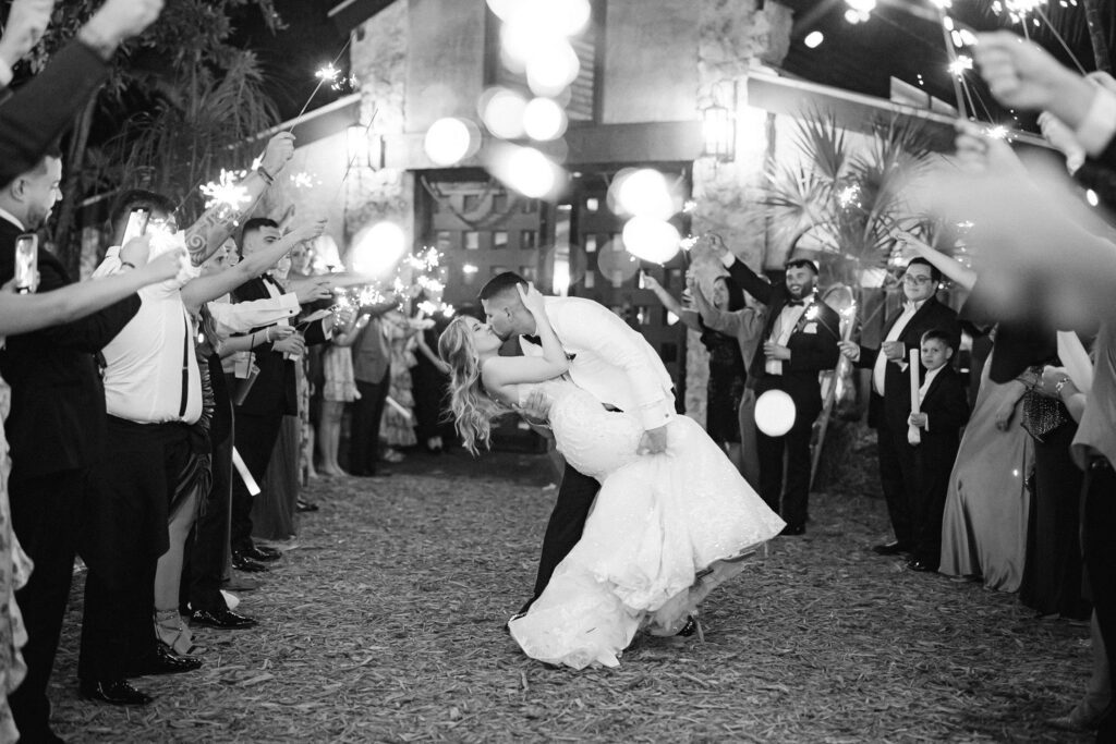 Black and white image of the newlyweds kissing during their sparkler exit at the Cooper Estate.